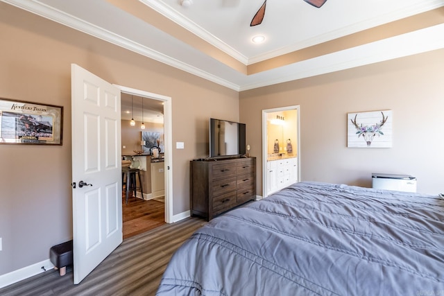 bedroom with baseboards, ornamental molding, wood finished floors, a raised ceiling, and a ceiling fan