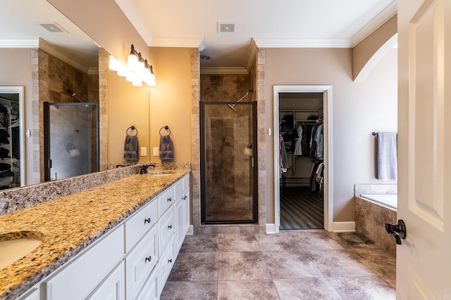 full bath with a stall shower, ornamental molding, visible vents, and a sink