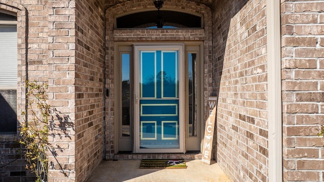 property entrance featuring brick siding