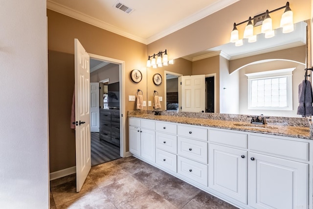 bathroom featuring visible vents, baseboards, double vanity, ornamental molding, and a sink