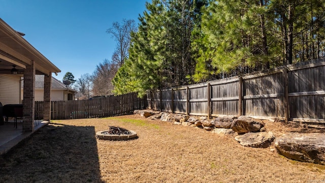 view of yard featuring a patio area, a fenced backyard, and an outdoor fire pit