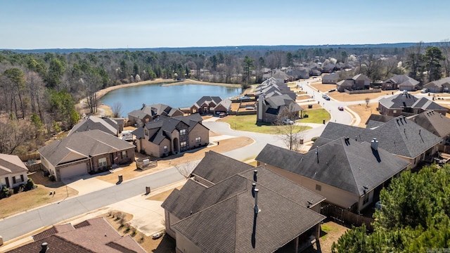 drone / aerial view featuring a forest view, a residential view, and a water view