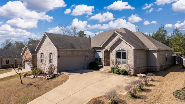 view of front of property featuring brick siding, driveway, an attached garage, and a shingled roof