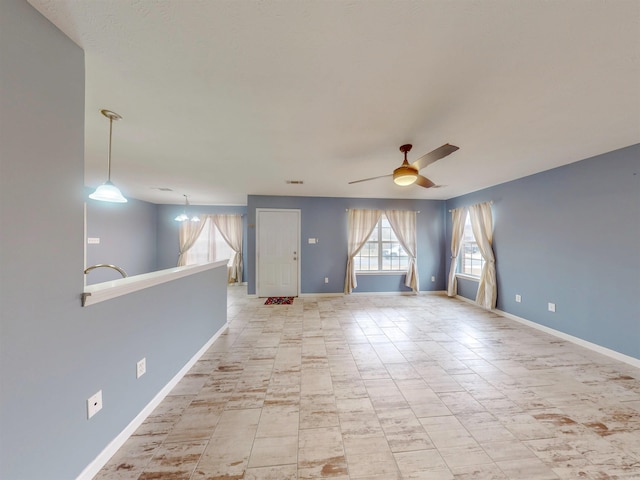 empty room with a ceiling fan and baseboards