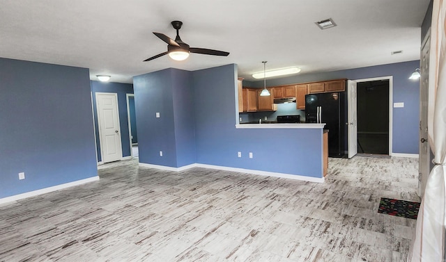 unfurnished living room with visible vents, baseboards, and a ceiling fan