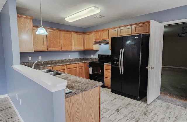 kitchen with black appliances, under cabinet range hood, a sink, a peninsula, and hanging light fixtures