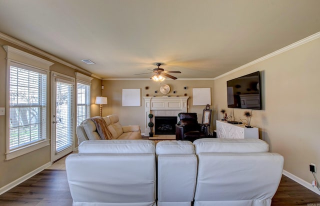 living room featuring visible vents, ornamental molding, ceiling fan, and wood finished floors