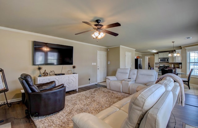 living area featuring ceiling fan with notable chandelier, wood finished floors, and ornamental molding