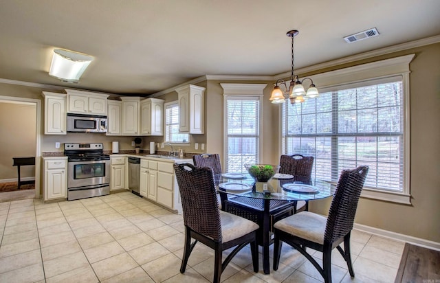 kitchen featuring visible vents, a sink, ornamental molding, appliances with stainless steel finishes, and a chandelier