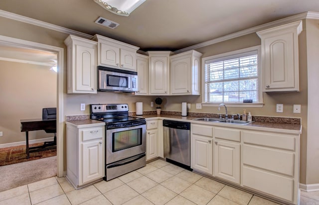 kitchen with visible vents, a sink, white cabinetry, stainless steel appliances, and crown molding