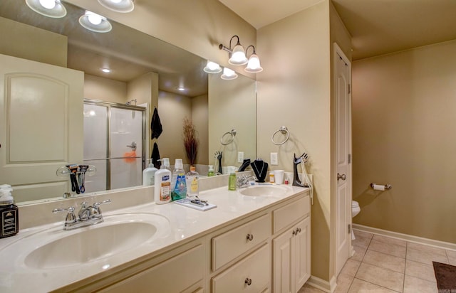 full bathroom featuring a sink, double vanity, a stall shower, and tile patterned floors