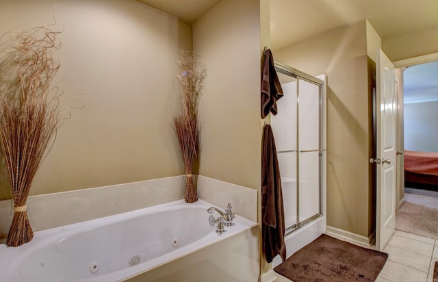 bathroom featuring tile patterned flooring, a shower stall, a jetted tub, and baseboards