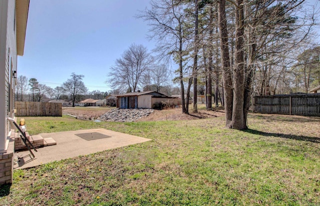 view of yard with an outbuilding, a storage shed, a patio, and fence