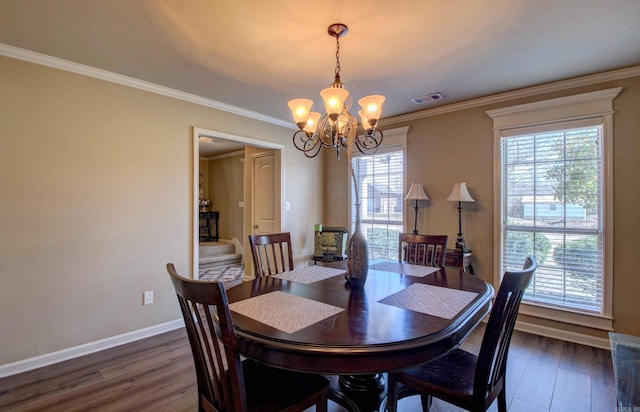 dining area featuring a chandelier, visible vents, dark wood-type flooring, and ornamental molding