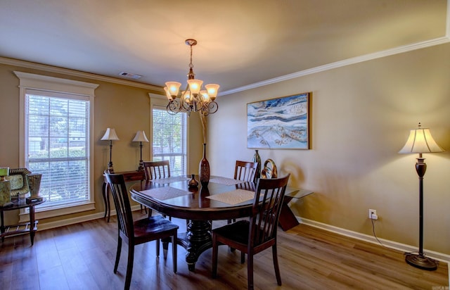 dining space featuring a chandelier, wood finished floors, and ornamental molding