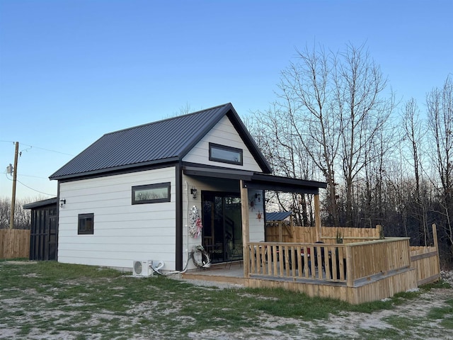 rear view of house with metal roof and fence