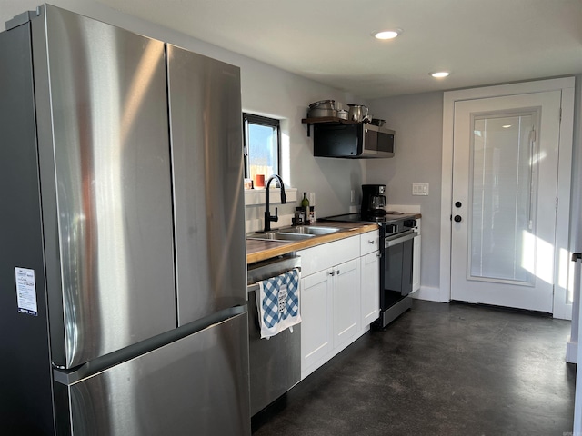 kitchen featuring a sink, white cabinetry, recessed lighting, stainless steel appliances, and butcher block counters