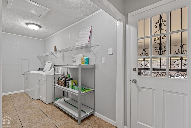 clothes washing area featuring attic access, light tile patterned floors, laundry area, washer and dryer, and a textured ceiling