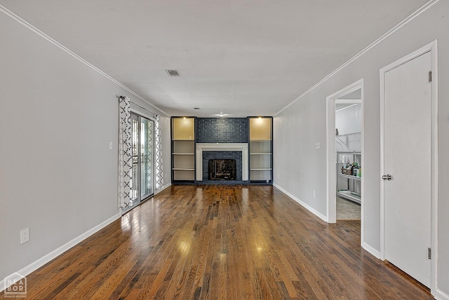 unfurnished living room with visible vents, baseboards, hardwood / wood-style floors, and crown molding