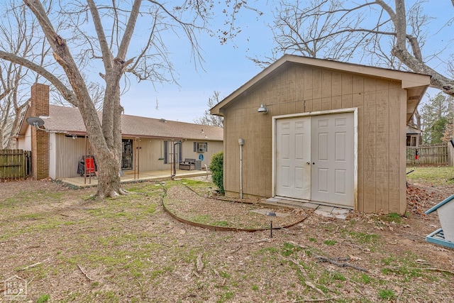 view of outbuilding featuring an outdoor structure and fence