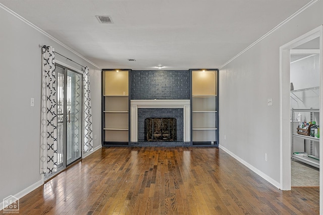 unfurnished living room with hardwood / wood-style floors, a brick fireplace, visible vents, and ornamental molding