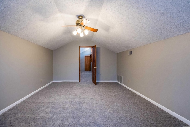 additional living space featuring a ceiling fan, visible vents, baseboards, lofted ceiling, and a textured ceiling