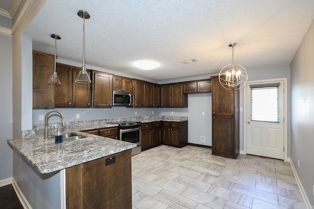 kitchen with dark brown cabinetry, light stone counters, a peninsula, stainless steel appliances, and a sink