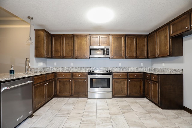 kitchen with stainless steel appliances, light stone countertops, dark brown cabinetry, and a textured ceiling