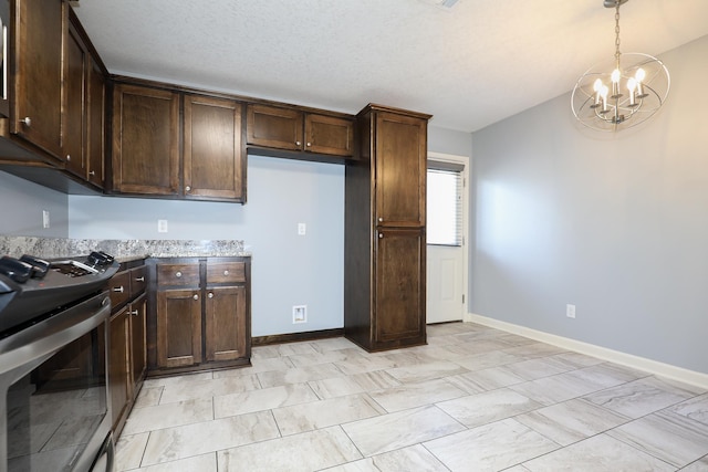 kitchen featuring stainless steel range with gas cooktop, an inviting chandelier, baseboards, dark brown cabinets, and hanging light fixtures