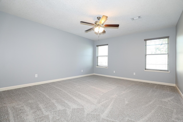 spare room featuring baseboards, visible vents, ceiling fan, a textured ceiling, and carpet flooring