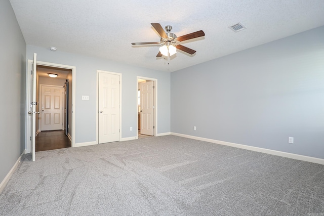 unfurnished bedroom featuring visible vents, baseboards, ceiling fan, carpet flooring, and a textured ceiling