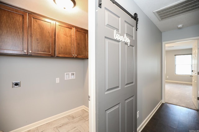 laundry area with visible vents, hookup for an electric dryer, baseboards, cabinet space, and a barn door