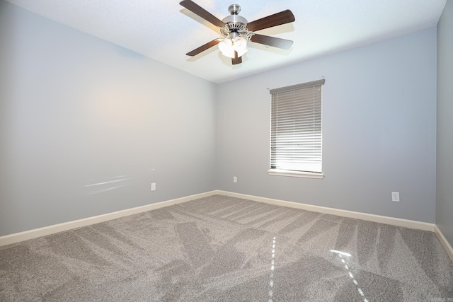 carpeted spare room featuring a ceiling fan and baseboards