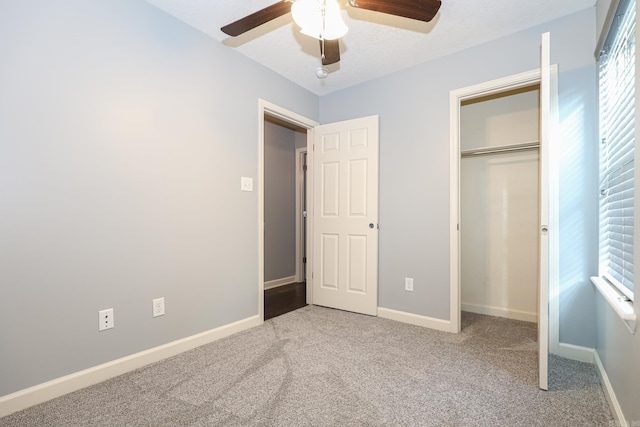 unfurnished bedroom with a closet, ceiling fan, carpet, and baseboards