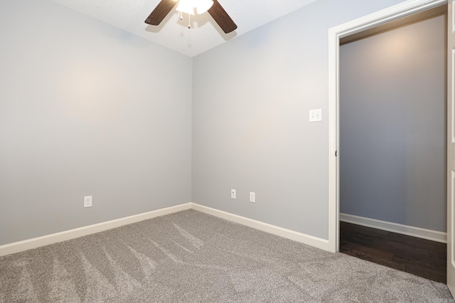 carpeted empty room featuring a ceiling fan and baseboards