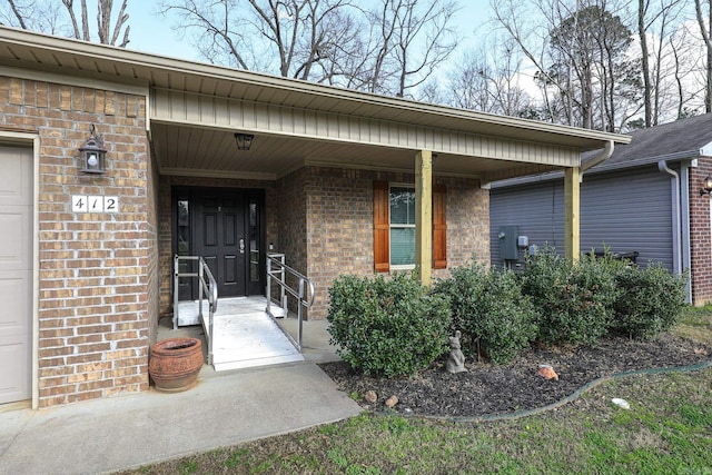 property entrance featuring brick siding and covered porch