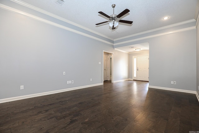 spare room with dark wood-style floors, visible vents, a ceiling fan, baseboards, and ornamental molding