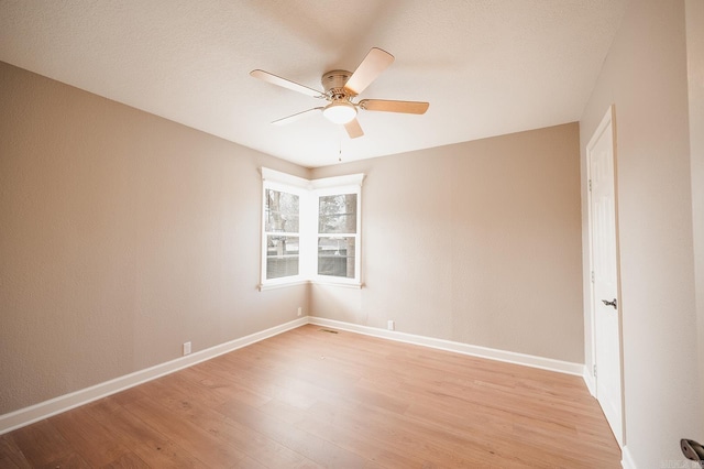 empty room with baseboards, light wood-style floors, and ceiling fan