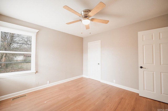 unfurnished room with visible vents, a ceiling fan, light wood-type flooring, and baseboards