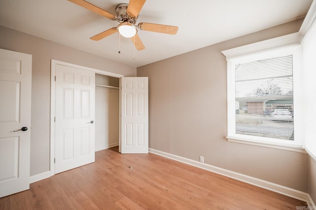 unfurnished bedroom with a closet, light wood-style flooring, a ceiling fan, and baseboards