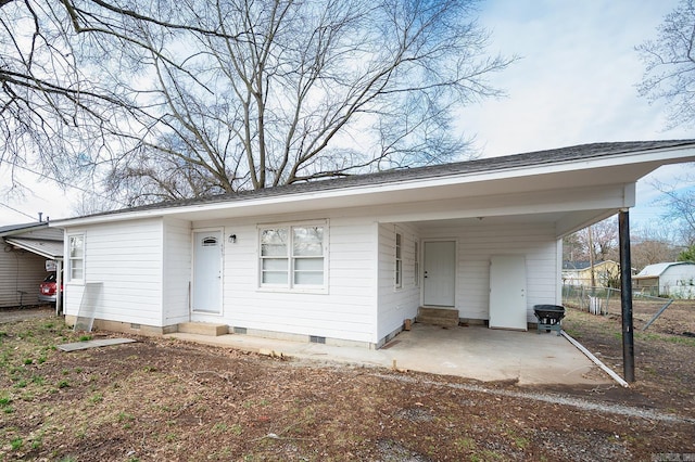 view of front of property with entry steps, a carport, fence, and crawl space