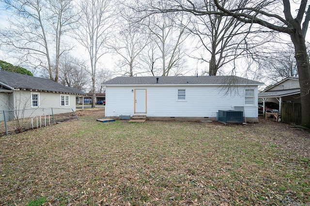 rear view of property with fence, central AC, entry steps, crawl space, and a lawn