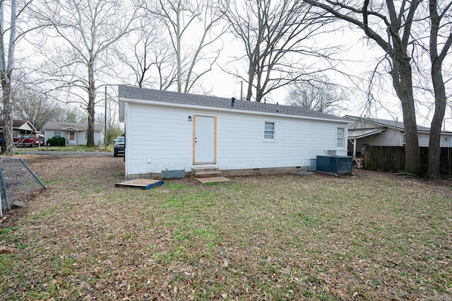 rear view of house featuring fence, entry steps, a lawn, cooling unit, and crawl space