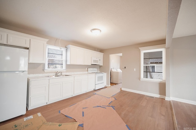 kitchen with white appliances, light countertops, light wood-type flooring, and a sink