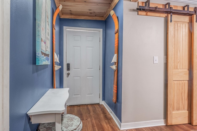 entryway with baseboards, wood ceiling, and wood finished floors