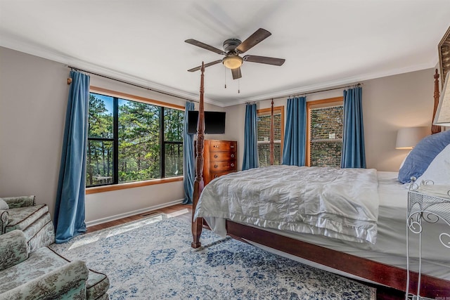 bedroom featuring wood finished floors, baseboards, ceiling fan, and crown molding