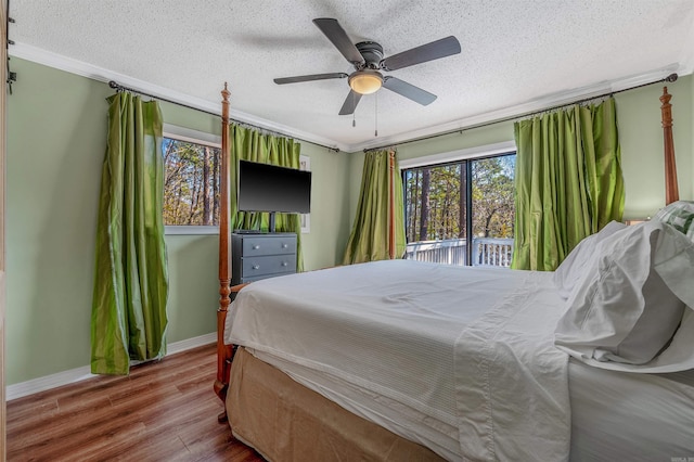 bedroom with ceiling fan, baseboards, ornamental molding, wood finished floors, and a textured ceiling