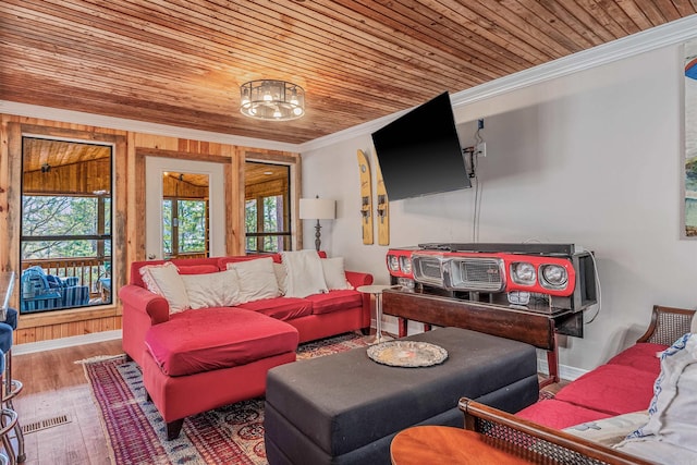 living area with wooden ceiling, wood finished floors, baseboards, and ornamental molding