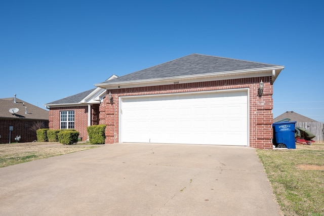 ranch-style home featuring brick siding, concrete driveway, a garage, and roof with shingles