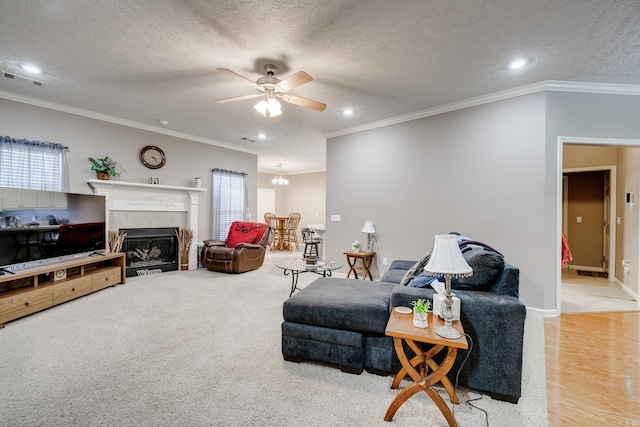 living room featuring a textured ceiling, a glass covered fireplace, and ceiling fan